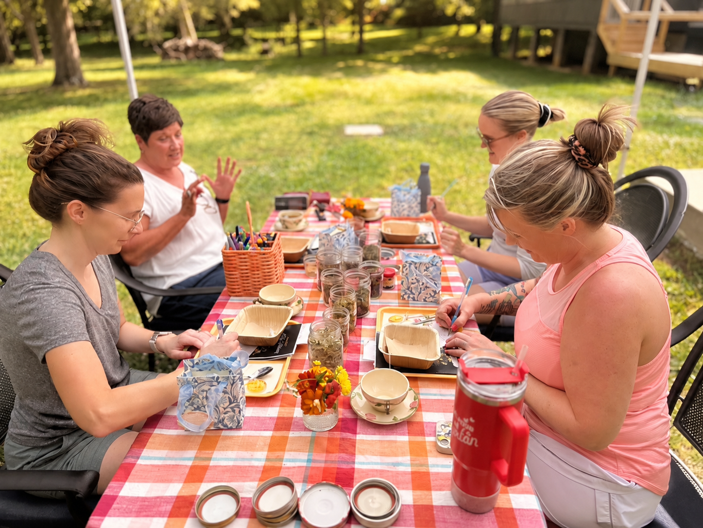 A calming tea-making plant workshop with hands around a table
