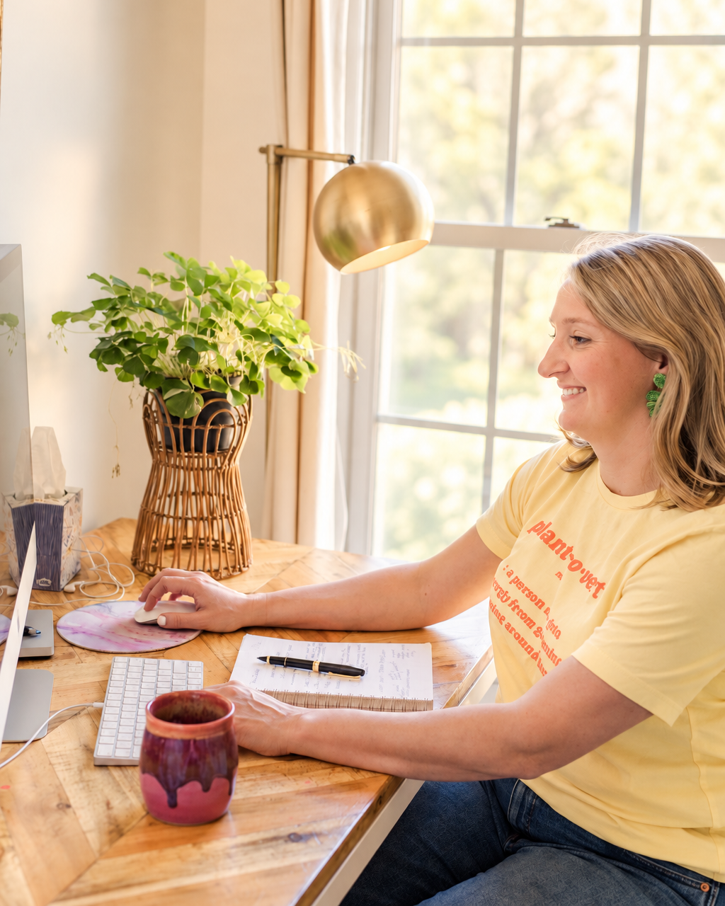 Katie leading a virtual session at her desk beside a plant